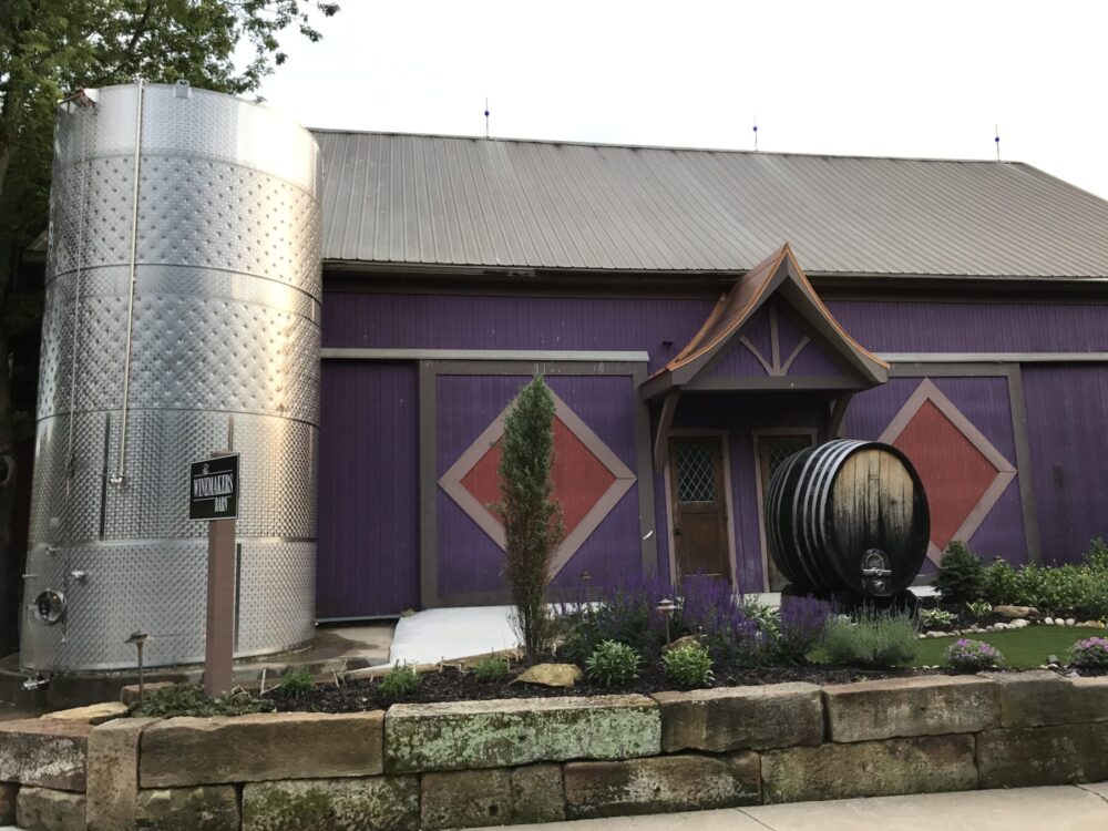 A purple building with a large metal tank on the side of it.
