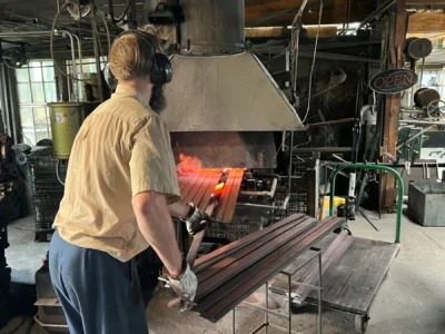 A rare sight of a fourth generation Buggy Maker hard at work heating up buggy spring material in the blast furnace. A rare sight of a fourth generation Buggy Maker hard at work heating up buggy spring material in the blast furnace.