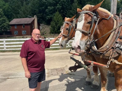 Tour Guide Richard Troyer posing with a pair of Belgian draft horse while we talked with the farmer we found in the back country.